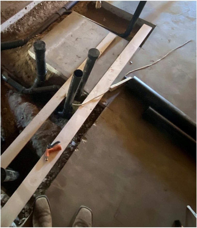 Close view of black rough plumbing lines and trench work